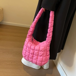 Gros plan d'un sac matelassé rose vif avec texture bouffante et bandoulière chic