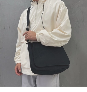 Sac messager pratique en toile noire porté avec une large bandoulière réglable