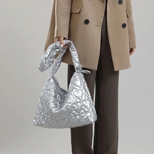 Macro shot of silver metallic quilted tote bag with heart-shaped stitching detail