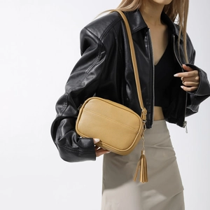 Sac bandoulière minimaliste en cuir jaune avec détail de pompon à chaîne élégant
