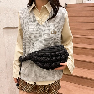 Vue détaillée du sac bandoulière matelassé noir avec tissu texturé porté par un mannequin