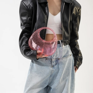 Close-up of pink translucent acrylic moon bag with bubble texture held by model