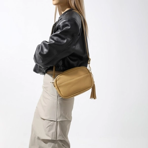 Détail du sac à bandoulière jaune moutarde en cuir grainé avec franges et fermeture dorée
