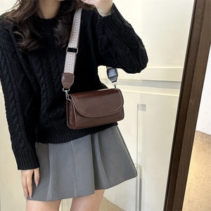 Detail of coffee brown PU leather crossbody bag with wide herringbone woven strap
