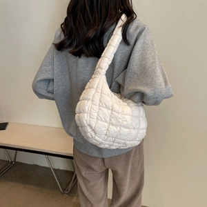 Détail du sac bandoulière blanc matelassé montrant la texture et le style nuage