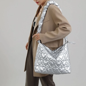 Close-up of heart-shaped quilting and metallic silver nylon fabric on women's tote bag