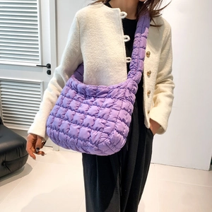 Detail view of purple quilted puffer crossbody bag made of lightweight nylon fabric