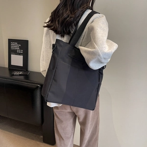 Sac à bandoulière moderne en nylon noir imperméable montrant la taille et la coupe