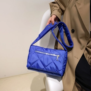 Dettaglio borsa trapuntata blu reale in nylon con cerniera argento e occhielli metallici