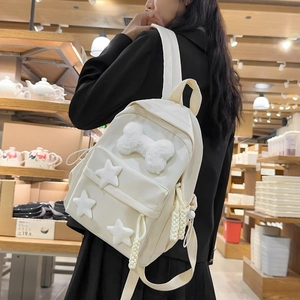 Detail view of nylon backpack featuring plush 3D star and bone cartoon decorations
