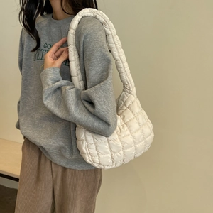 Mannequin portant un sac à bandoulière matelassé crème élégant en tissu nylon souple et rembourré