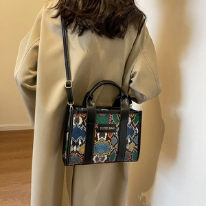 Detailed back view of a colorful faux leather tote bag worn with a stylish khaki trench coat
