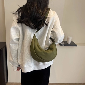 Detailed back view of an olive green nylon crescent crossbody bag with a wide strap