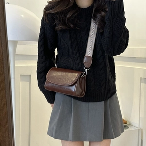 Close-up of vintage brown PU leather bag with patterned wide strap and magnetic flap