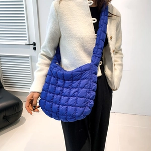 Detail of royal blue quilted crossbody bag showing bubble texture and soft padded shoulder strap