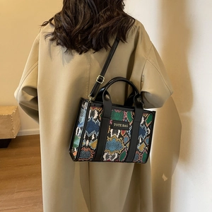Detailed view of chic faux leather tote bag with vibrant multi-color snakeskin pattern