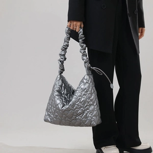 Close-up of heart-shaped quilted texture and scrunchie handle on silver nylon handbag