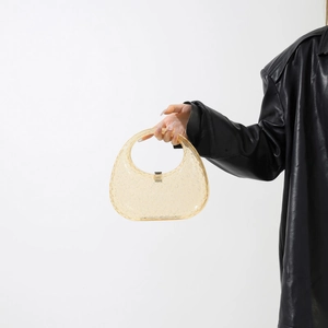 Detail of amber translucent acrylic handbag featuring unique textured dot pattern