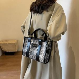 Minimalist snake print crossbody tote bag shown on model with chic black leather straps