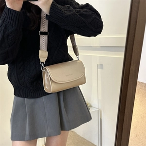 Detail of champagne gold PU crossbody bag with wide jacquard strap and brand embossing