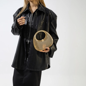 Detailed view of an amber acrylic crescent handbag with textured surface and smooth handle