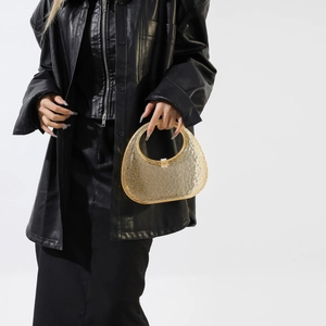 Amber acrylic handbag with round textured pattern styled on a black leather outfit