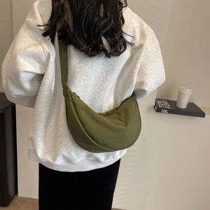 Detail view of the green nylon crescent crossbody bag with adjustable wide shoulder strap