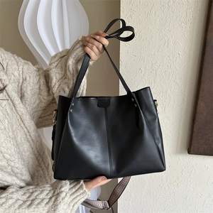 Detail of minimalist black PU tote bag featuring a decorative wide geometric woven strap