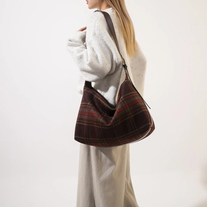 Detail view of large checkered tweed hobo bag with dark brown leather strap for women