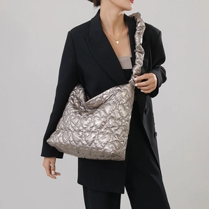 Detail of champagne metallic nylon handbag with heart quilting and ruched shoulder strap