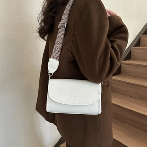 Detail of white rectangular PU crossbody bag with unique geometric wavy woven shoulder strap