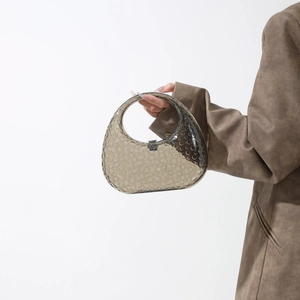 Detail of smoky gray acrylic handbag featuring dotted texture and oval pebble design