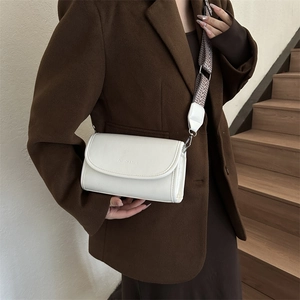 Minimalist white PU leather crossbody bag with wide woven strap on a female model