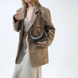 Close-up of a designer dark gray translucent acrylic handbag with round dot texture