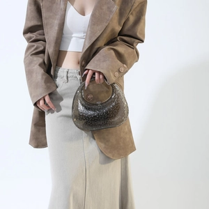 Detail of translucent dark brown acrylic handbag featuring unique textured dot patterns