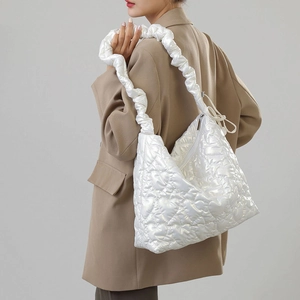Detail of white quilted heart patterns and ruffled cloud shoulder strap on nylon bag