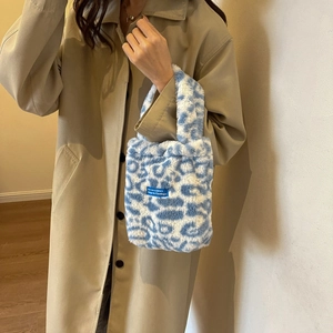 Detail of blue and white leopard faux fur handbag texture with woven logo patch