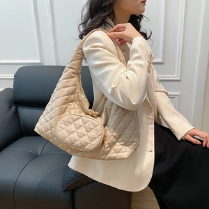 Quilted apricot Hobo shoulder bag with matching coin purse on an elegant model