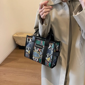 Close-up of stylish snakeskin pattern tote bag with black handles and subtle label
