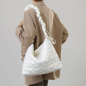 Detailed view of the white heart-quilted nylon tote bag with a soft scrunchie shoulder strap
