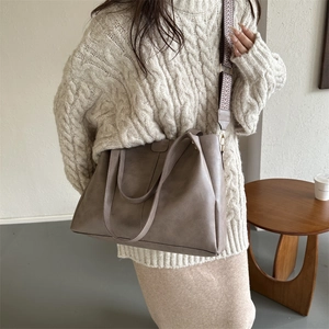Detail of coffee brown PU tote bag featuring a decorative wide patterned shoulder strap
