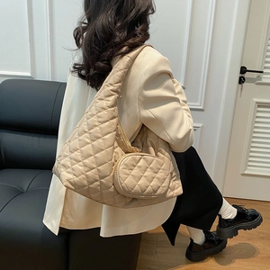 Close-up of beige quilted hobo bag with round coin pouch on a model for daily style
