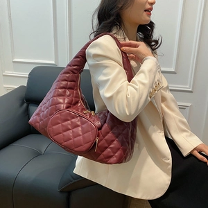 Detailed view of wine red quilted PU leather shoulder bag with gold zipper and side pouch