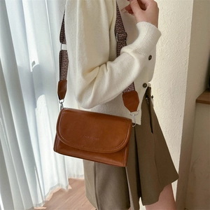 Detail view of brown PU leather crossbody bag featuring adjustable retro geometric strap