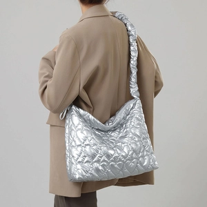 Detail of silver metallic handbag with heart quilting and ruched shoulder strap