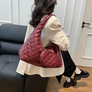 Deep red quilted hobo bag with matching round mini pouch worn by model in chic outfit