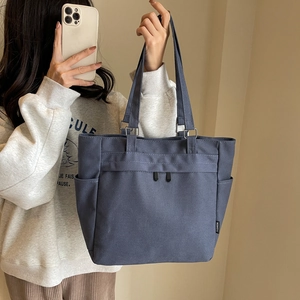 Macro detail of high-end canvas tote bag with side pockets and decorative zippers