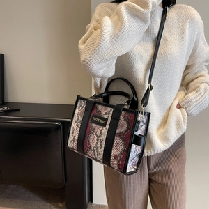 Detailed view of the textured snakeskin pattern and TOTE BAG label on the PU leather bag