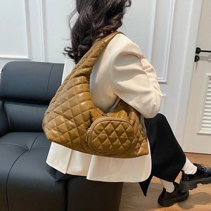 Detailed view of brown quilted crescent hobo bag with matching detachable round mini pouch