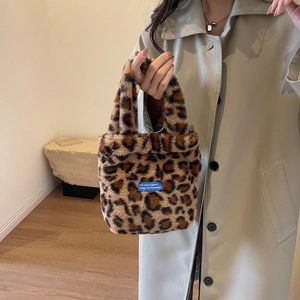 Close-up of brown leopard print faux fur handbag with blue rectangular woven brand label